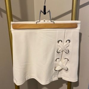 White mini skirt, shorts underneath. Silver details on side.